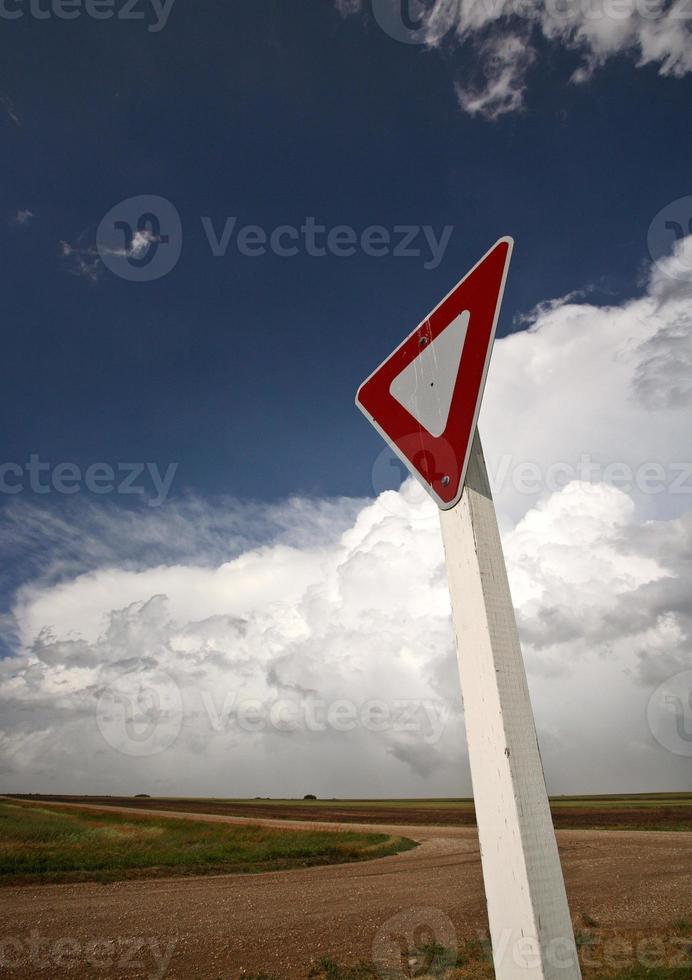 Yeild sign with Cumuloninumbus clouds in background photo