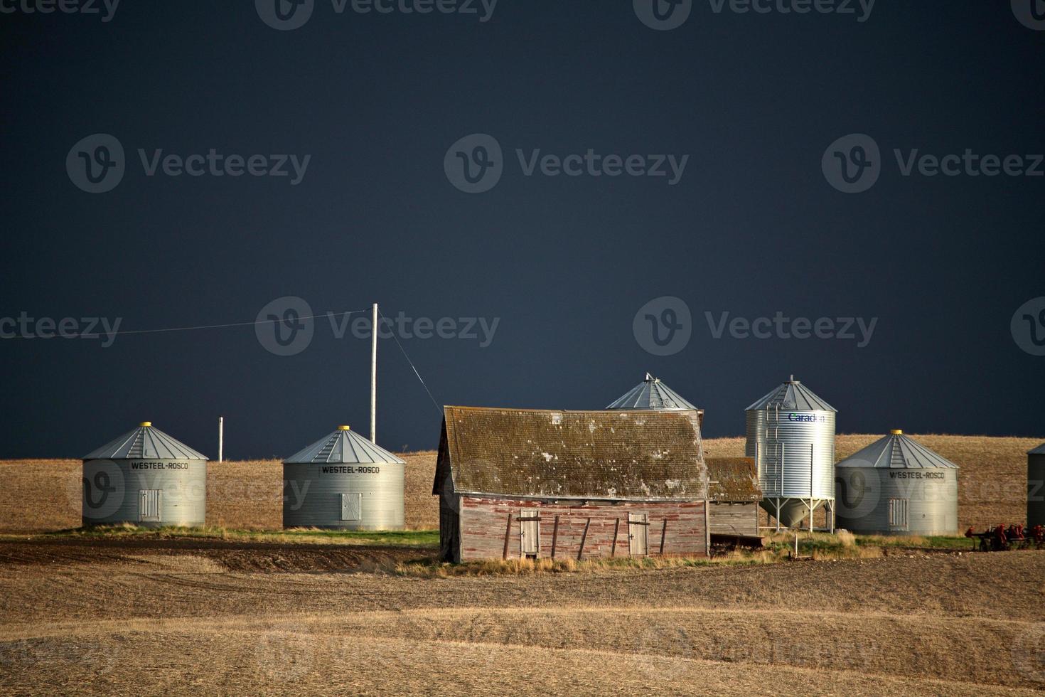 Storm clouds over farm buildings in Saskatchewan photo