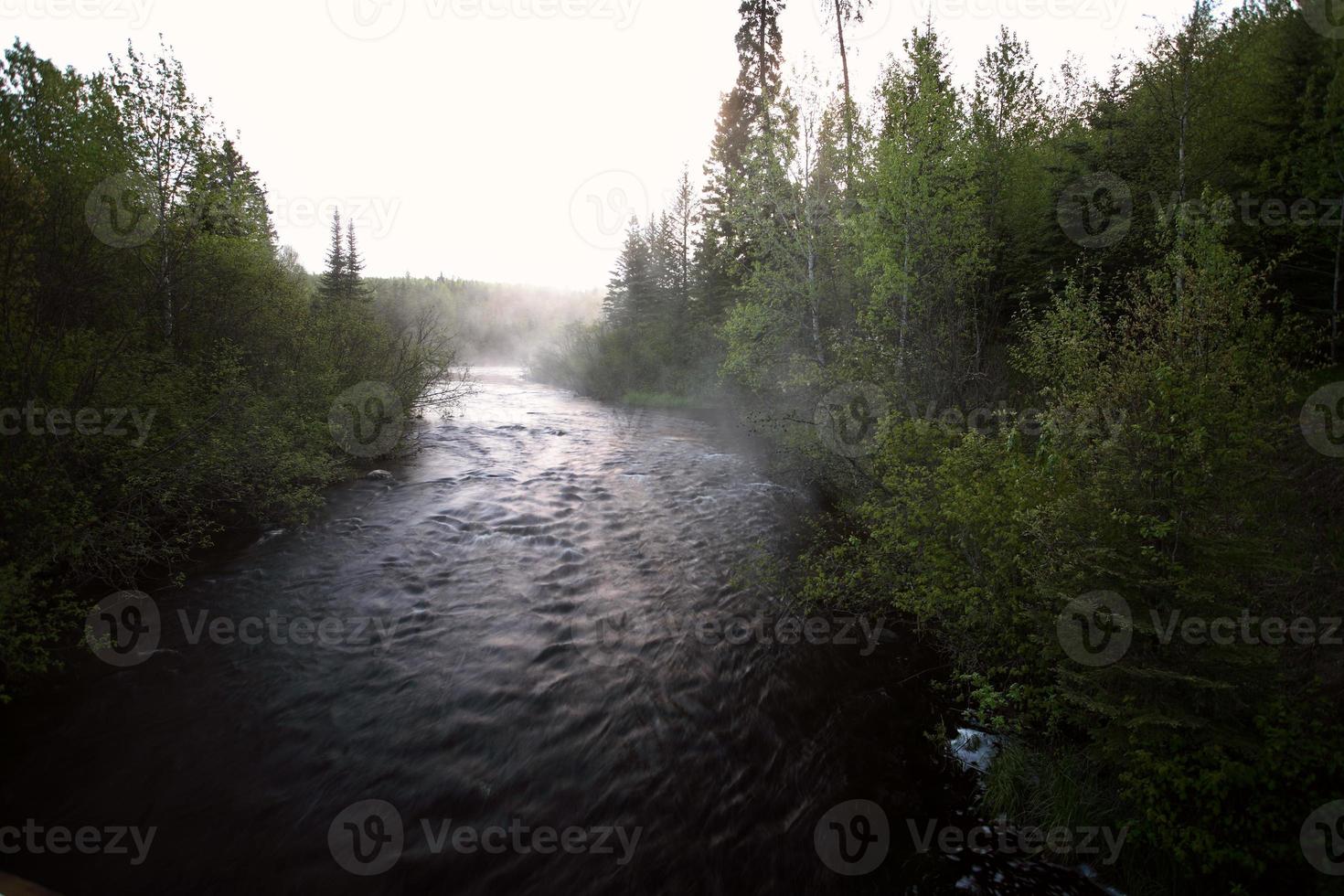 río arbolado temprano en la mañana en saskatchewan foto