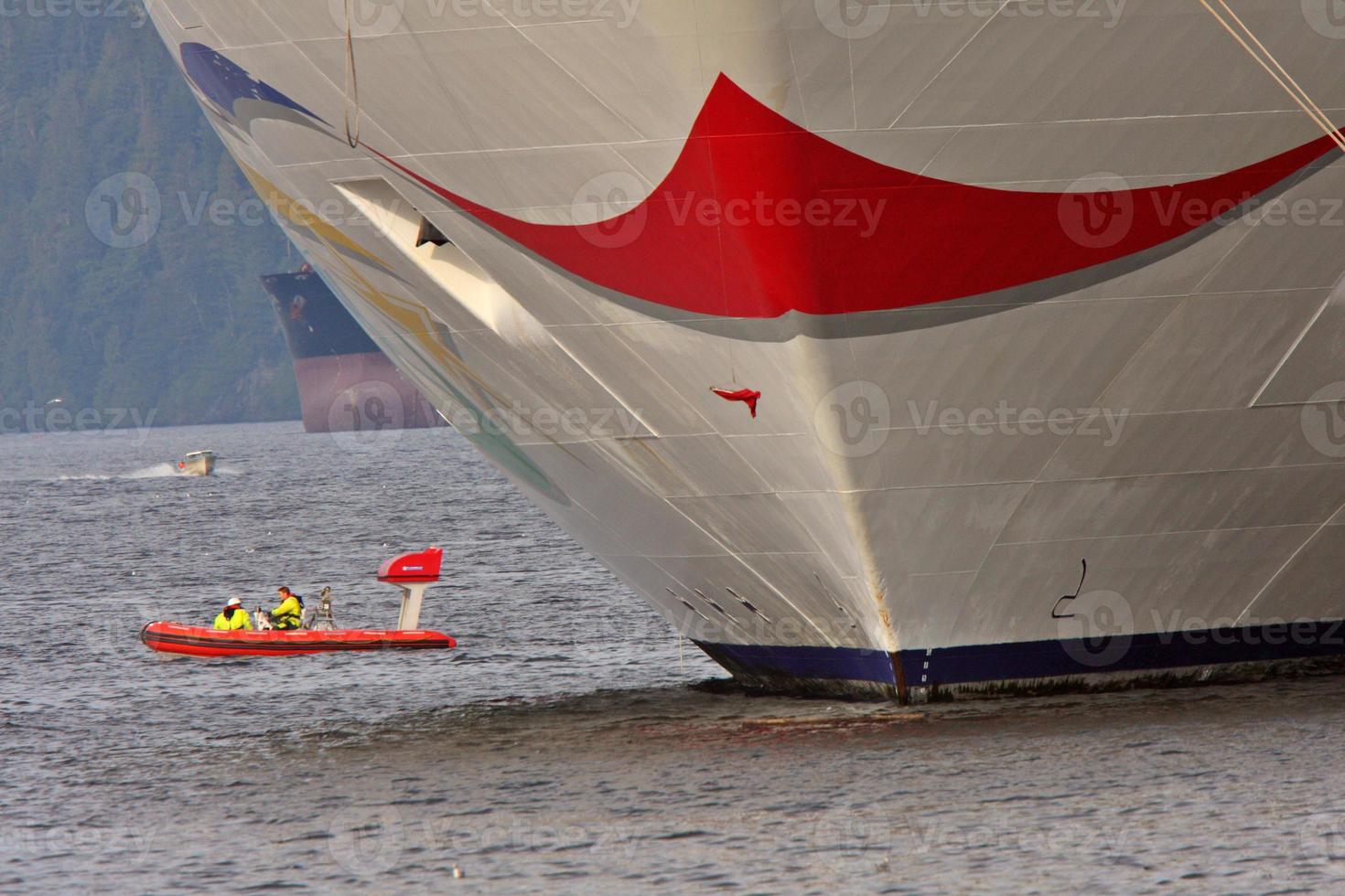 Motor boat passing cruise liner at dock in Prince Rupert photo