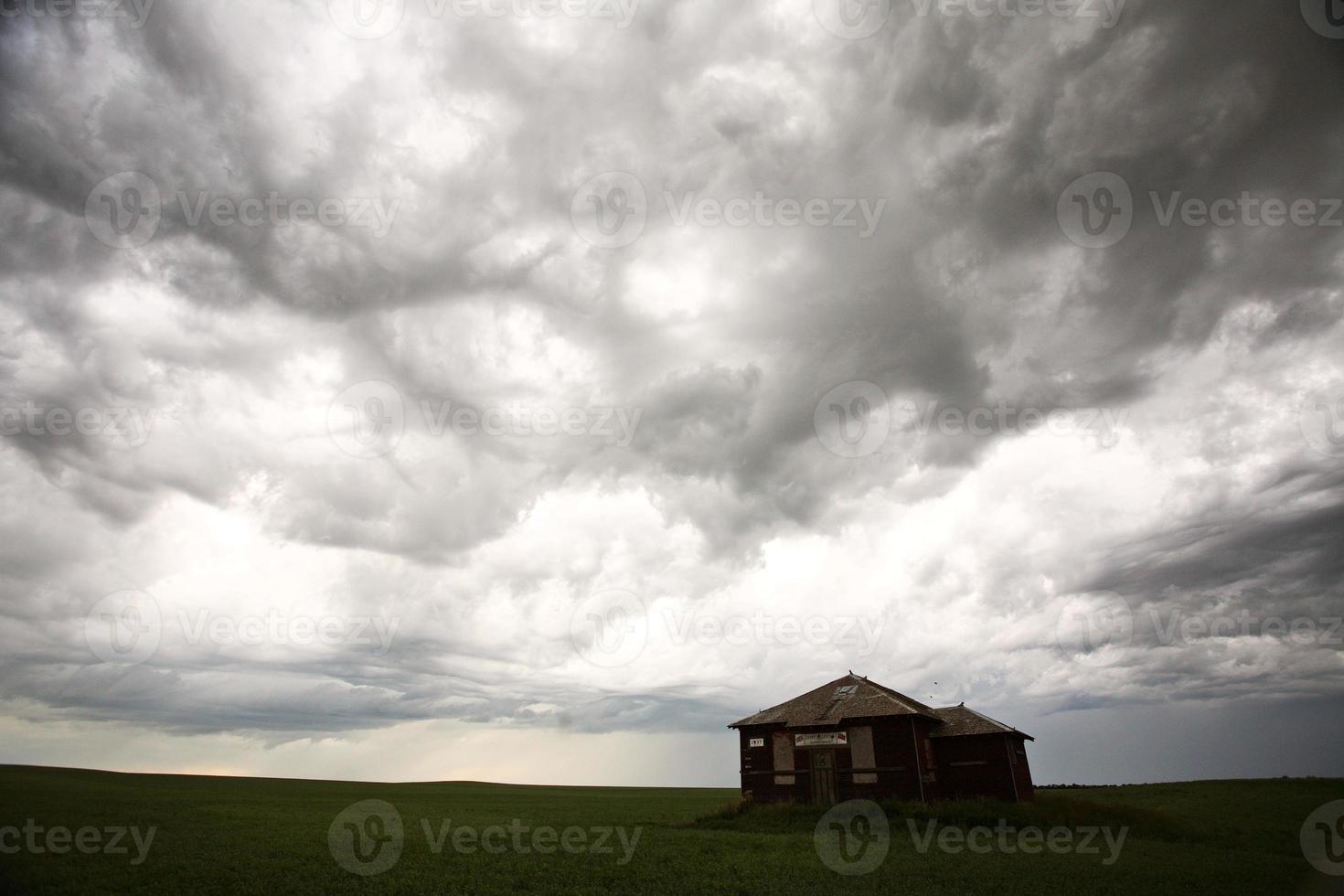 nubes de tormenta sobre una antigua casa de campo de saskatchewan foto
