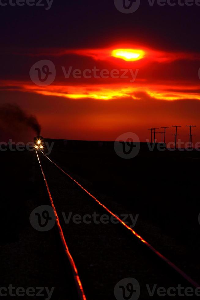 vista panorámica de un tren que se acerca cerca del atardecer foto