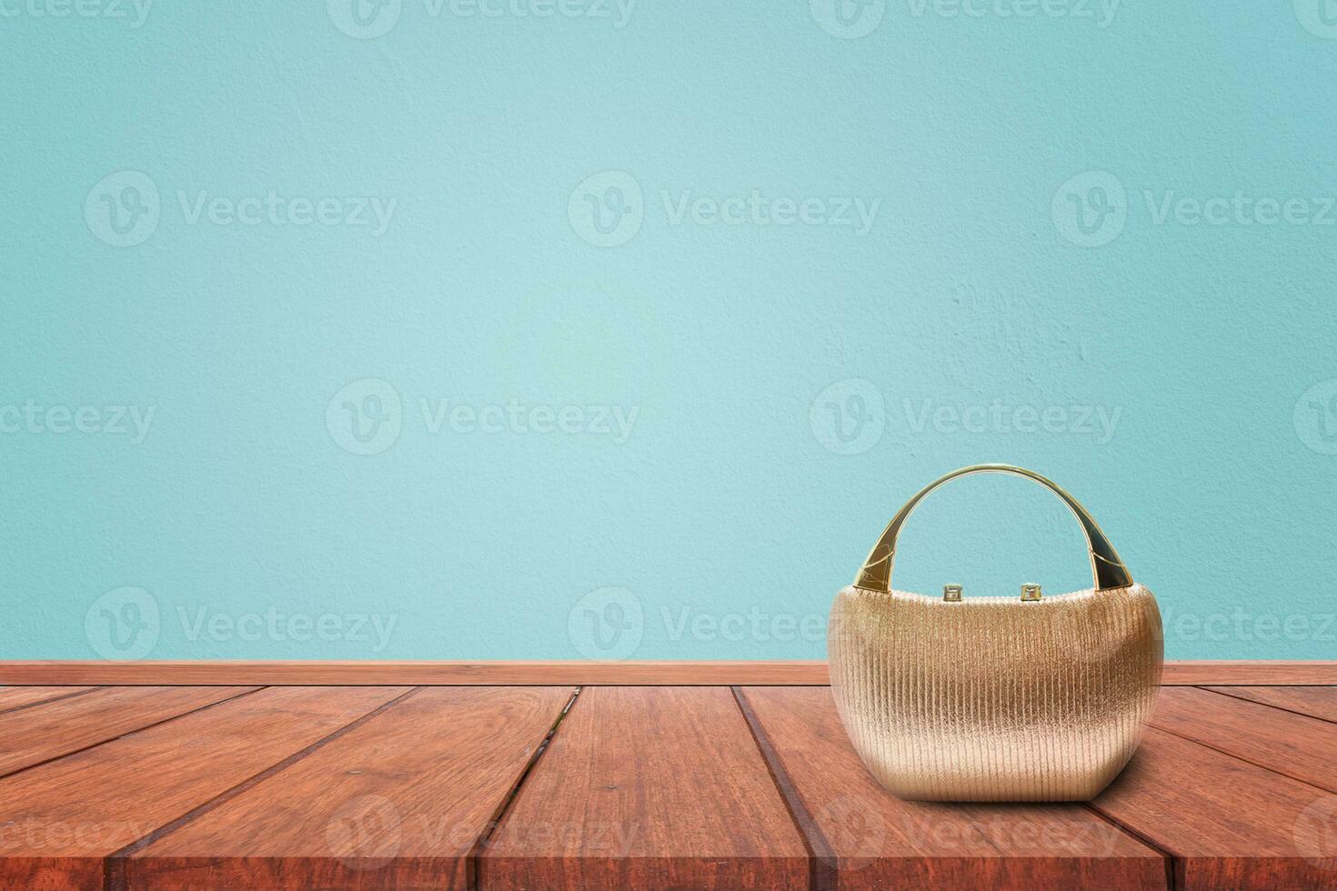 Women's handbag on wooden table with blue background. photo
