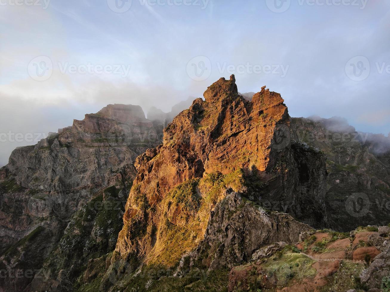 increíble, puesta de sol sobre el pico de una montaña en forma de pirámide. hermosa luz solar naranja dorada. viajar el mundo. vida nómada. estilo de vida aventurero. Días festivos. senderismo en la isla de madeira, portugal. foto