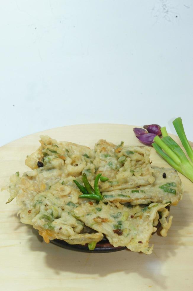 A traditional Javanese, Indonesian food made of tempeh coated with flour and half-fried green onions is called Tempe Mendoan photo