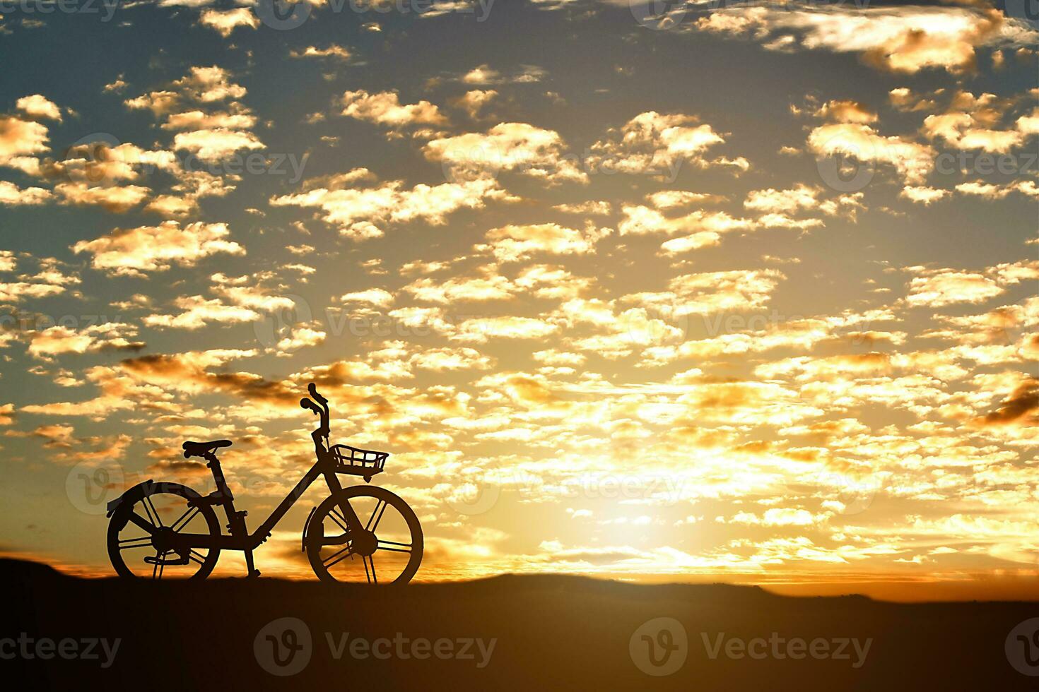 Silhouette of a bicycle against sunset background. photo