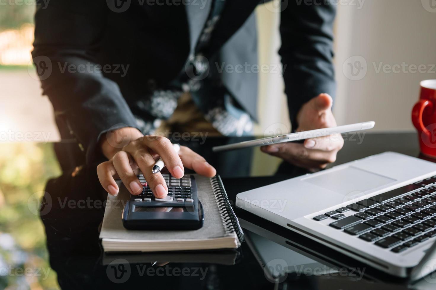 businessman working on desk office with using a calculator to calculate the numbers, finance accounting concept photo