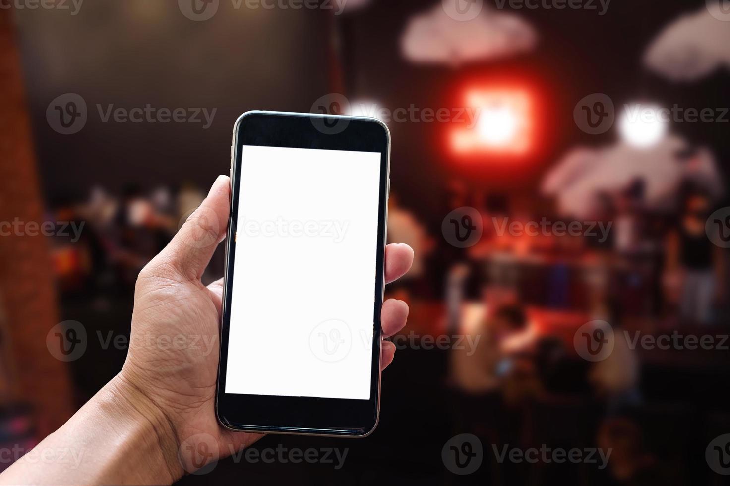 A woman hand holding smart phone device in the coffee shop or cafe background. photo