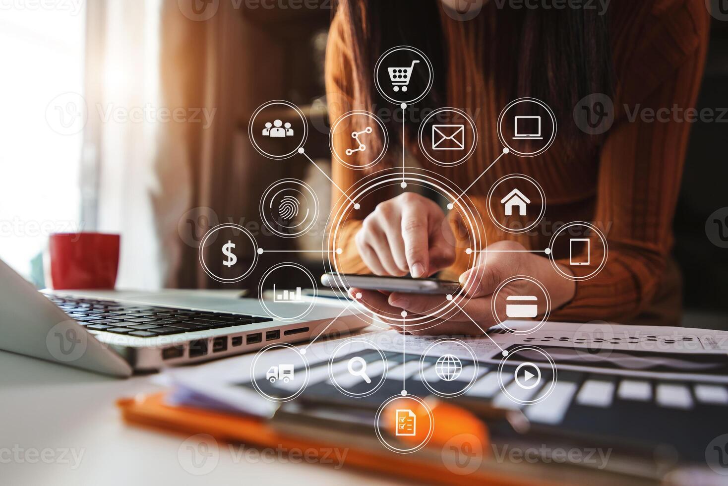 Hands using mobile phone in modern office with laptop photo