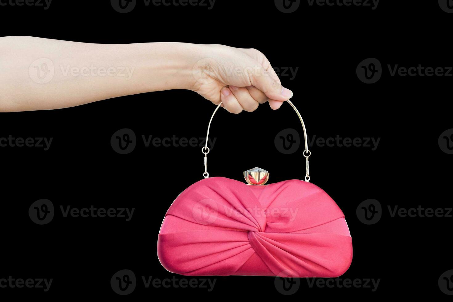 hand holding red luxury clutch bag isolated on black background. photo