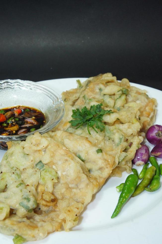A traditional Javanese, Indonesian food made of tempeh coated with flour and half-fried green onions is called Tempe Mendoan photo