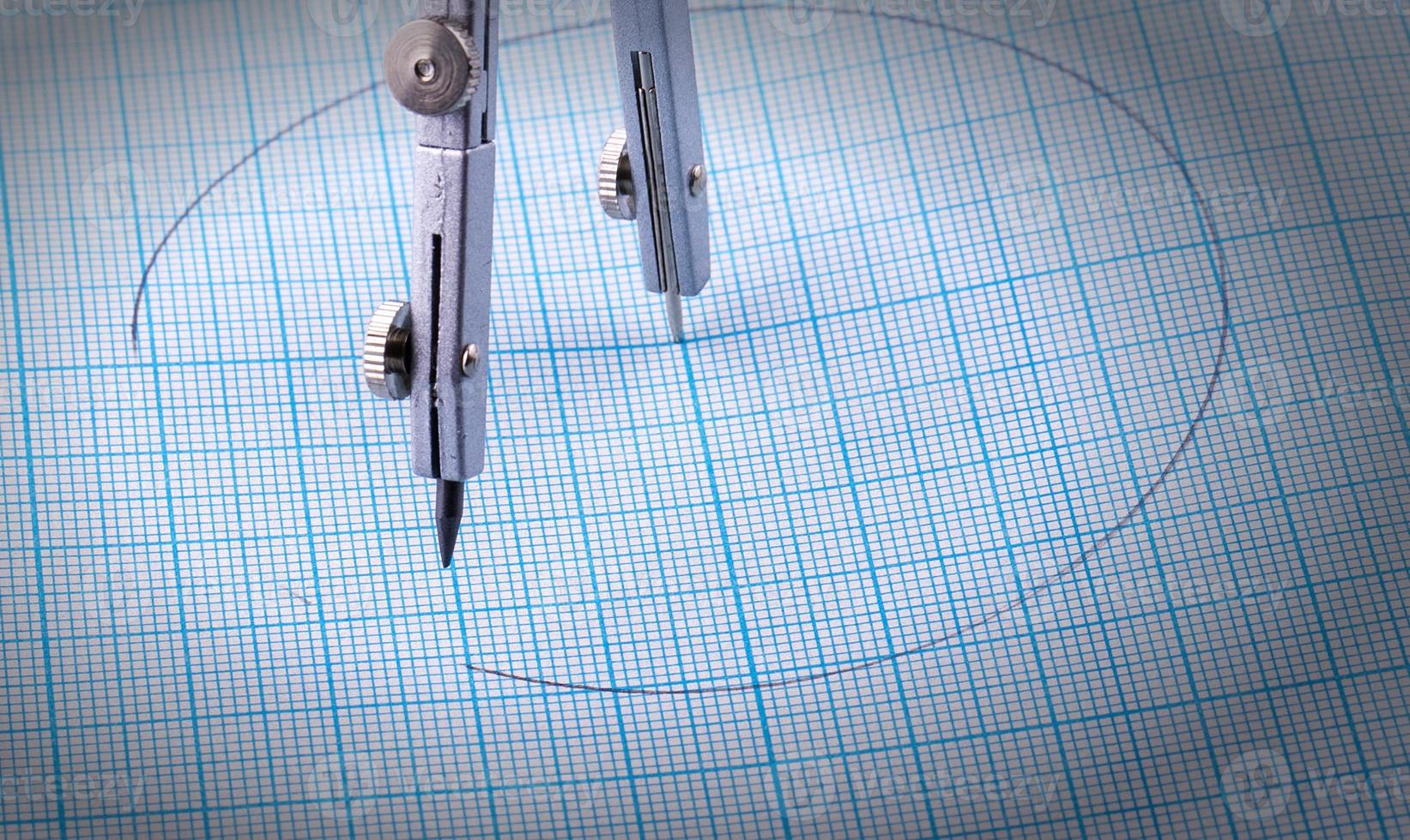 metal compasses over blue graph paper photo