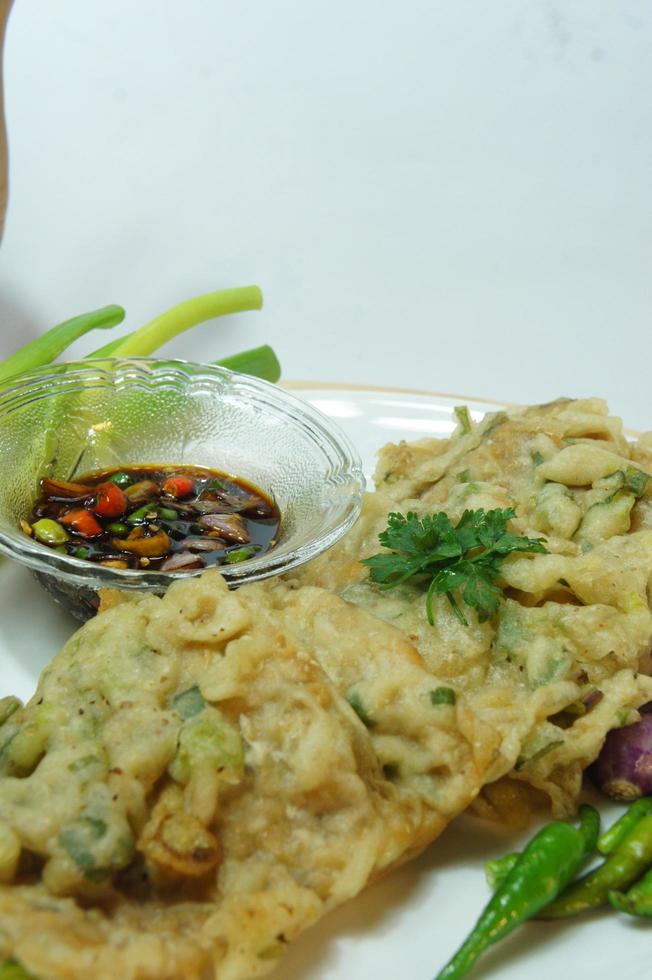 A traditional Javanese, Indonesian food made of tempeh coated with flour and half-fried green onions is called Tempe Mendoan photo