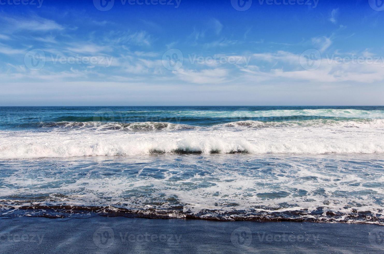 Big breaking Ocean wave on a black sandy beach on Pacific ocean photo