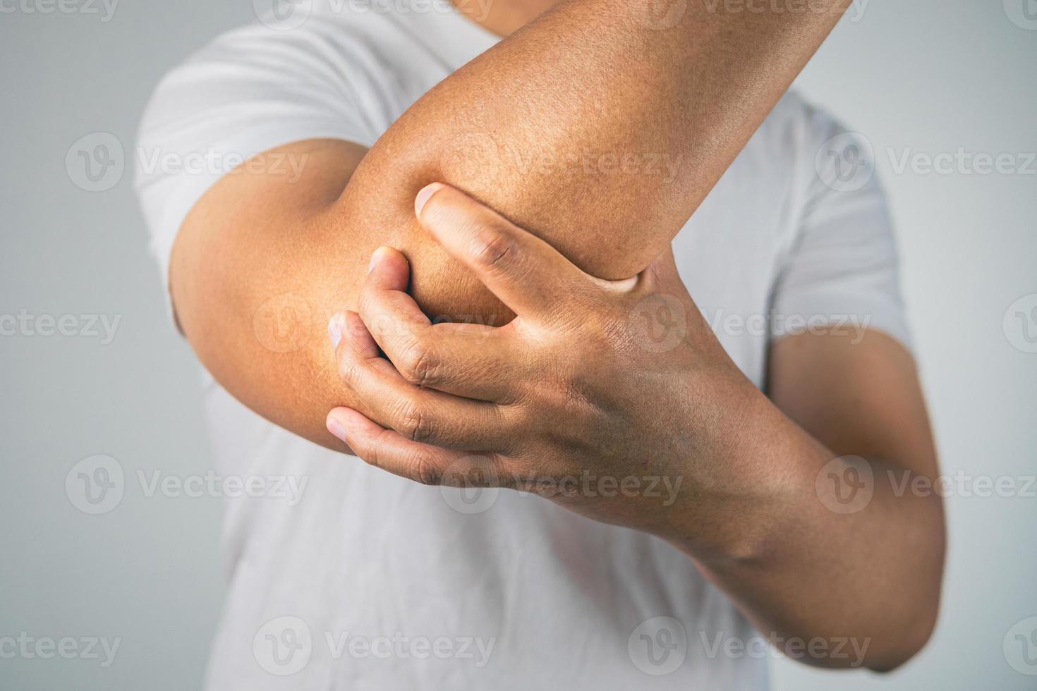 el hombre duele el codo. estos síntomas pueden ser causados por el deporte, el trabajo duro con el brazo. fotografía de cerca. foto