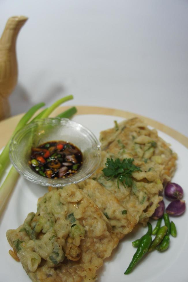 A traditional Javanese, Indonesian food made of tempeh coated with flour and half-fried green onions is called Tempe Mendoan photo