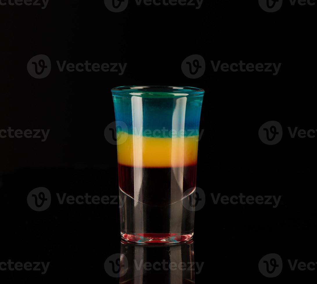 vaso de chupito con alcohol sobre un fondo oscuro foto