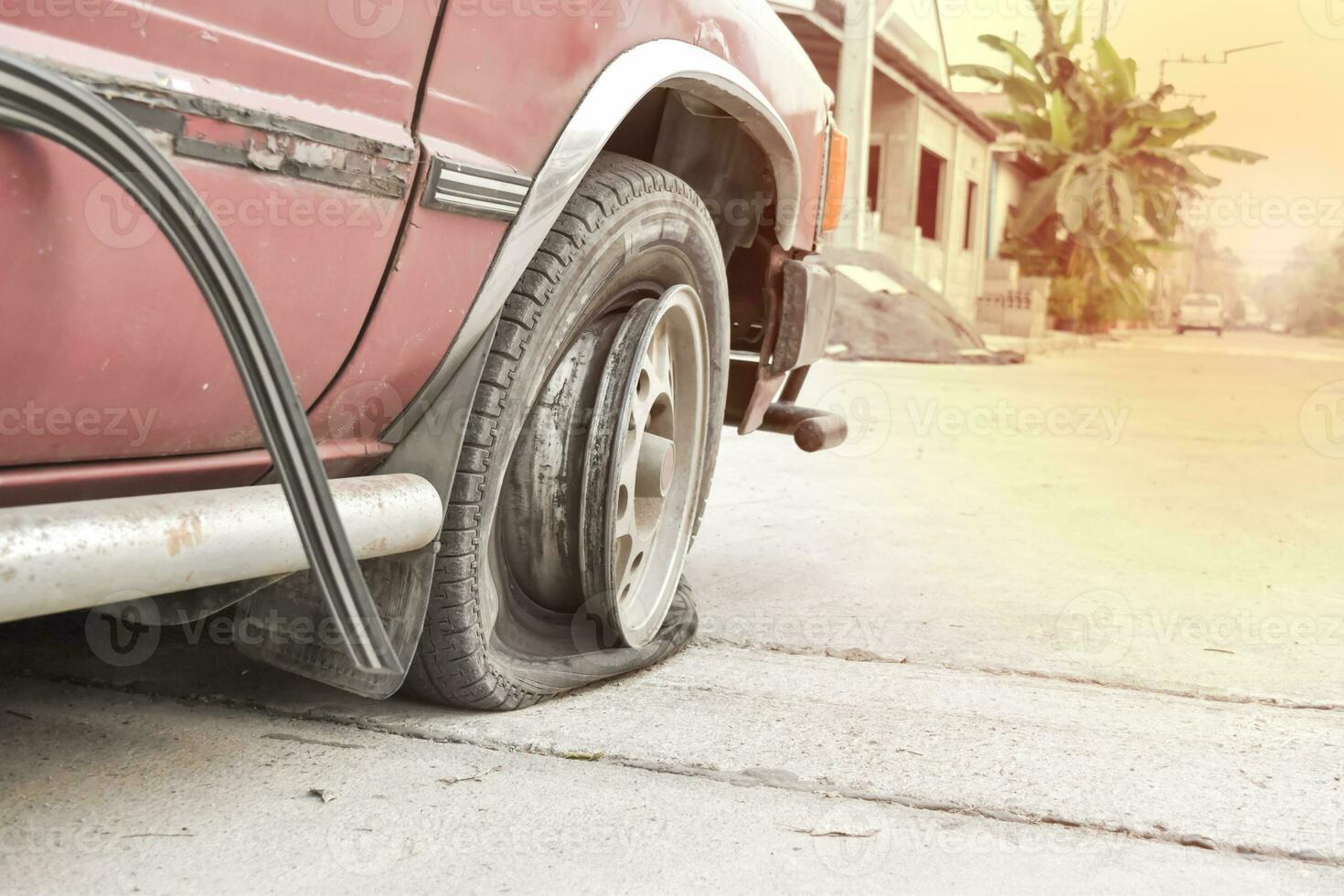 Abandoned car on the street. Flat tire and Tire burst photo