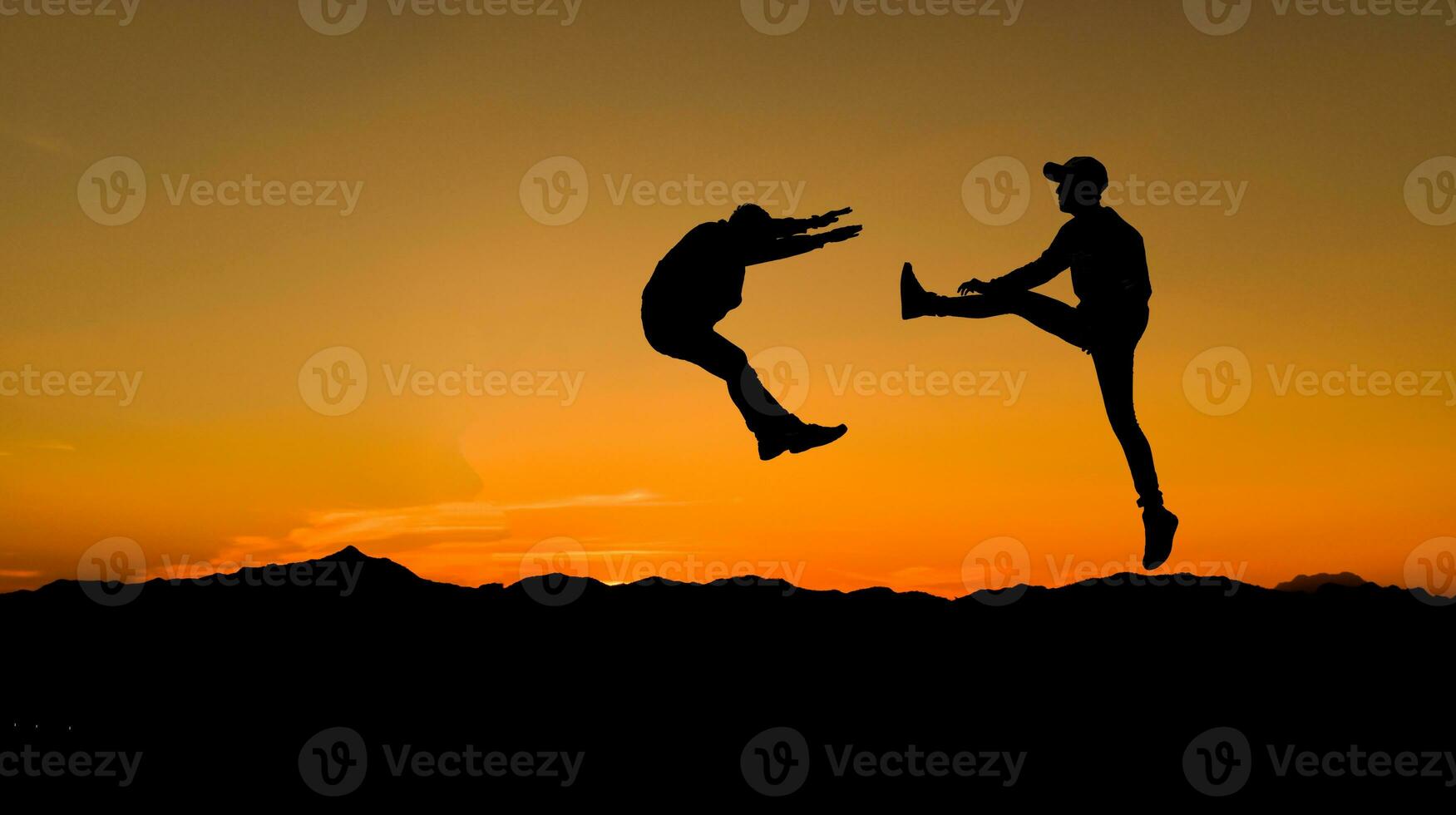 Silhouettes of two male fighters on sunset background. photo