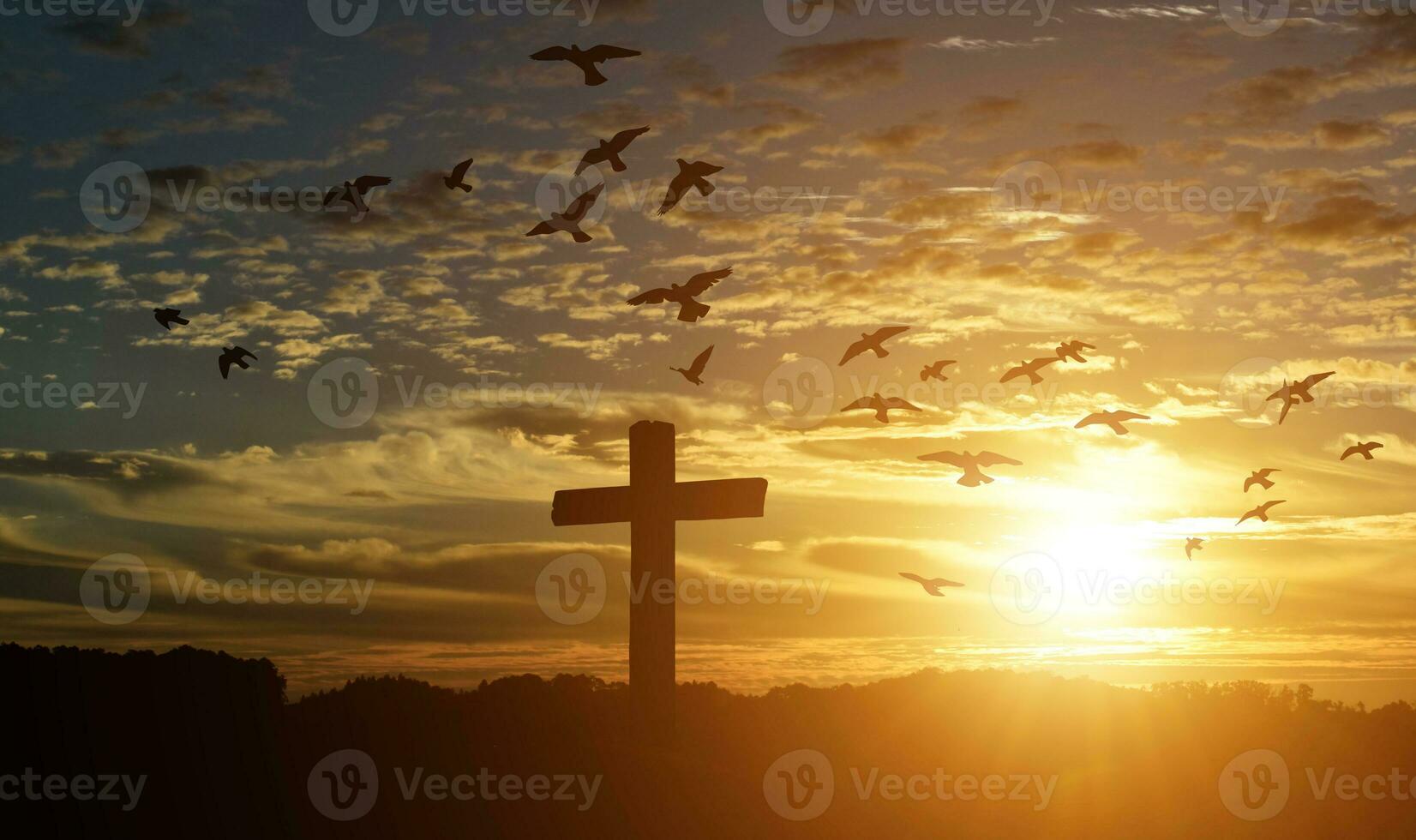 Silhouette of catholic cross at sunset background. photo