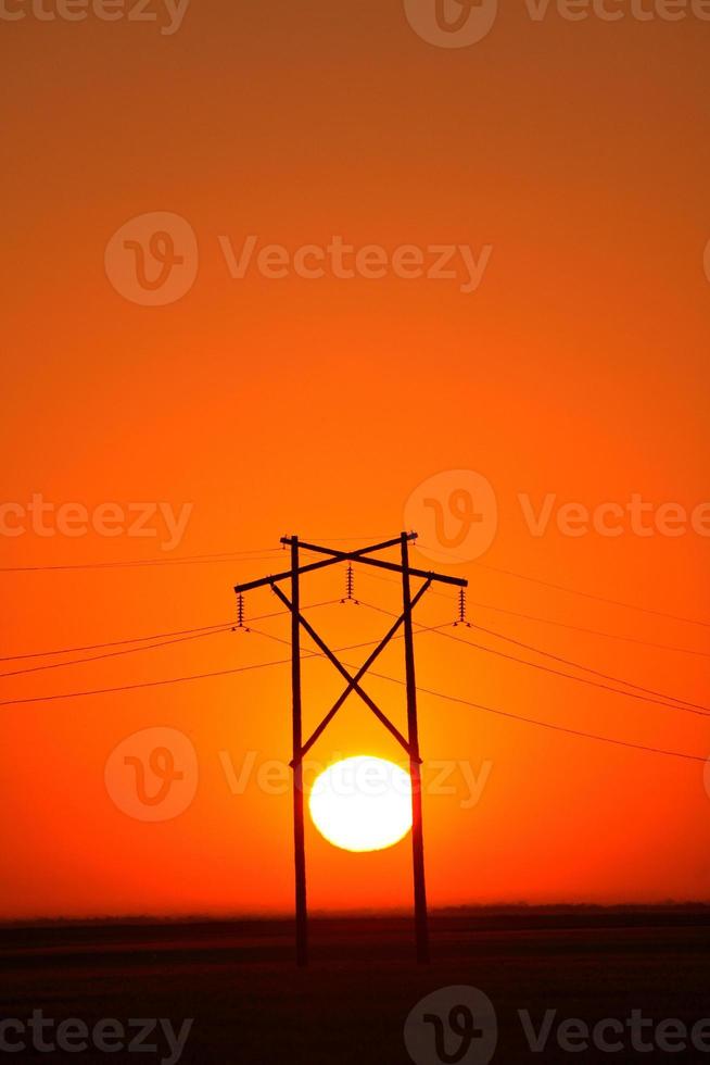 Sun setting behind Saskatchewan hydro tower photo