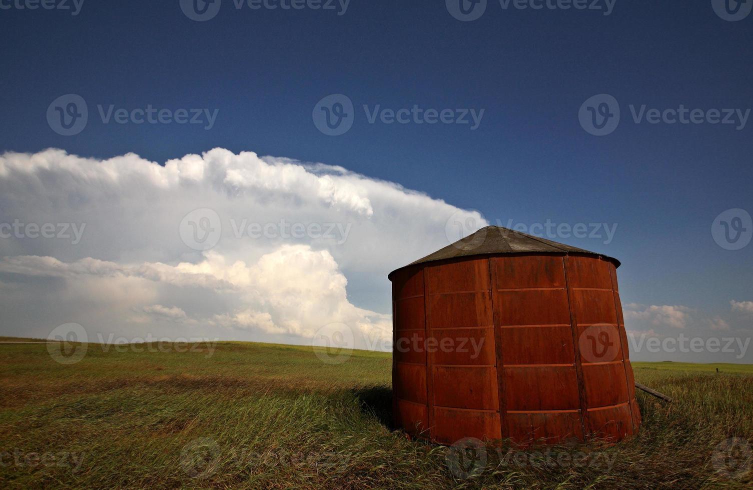 Wooden granary with Cumuloninumbus clouds in background photo