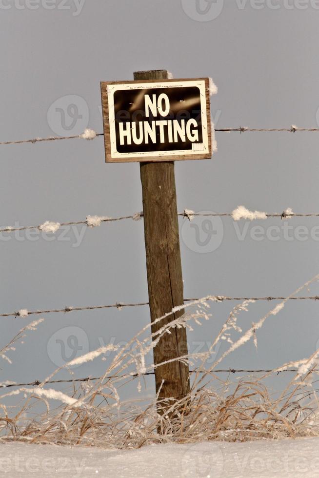 No Hunting sign near frost covered fence photo