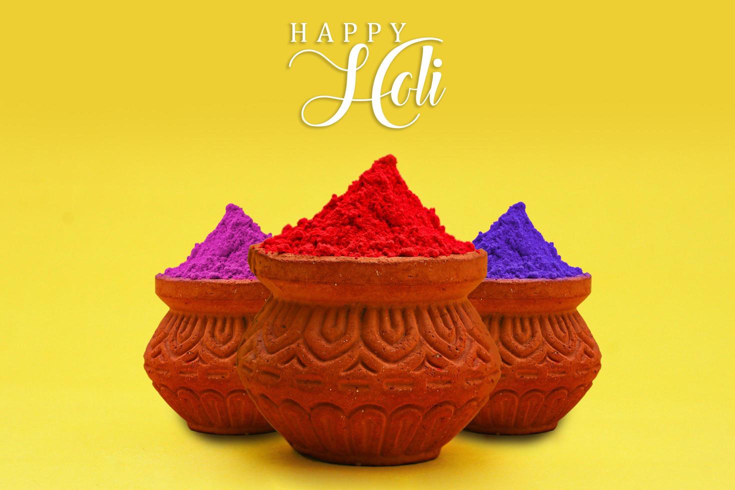 Indian festival Holi concept Multi color's bowl with colorful background and writing happy holi. photo