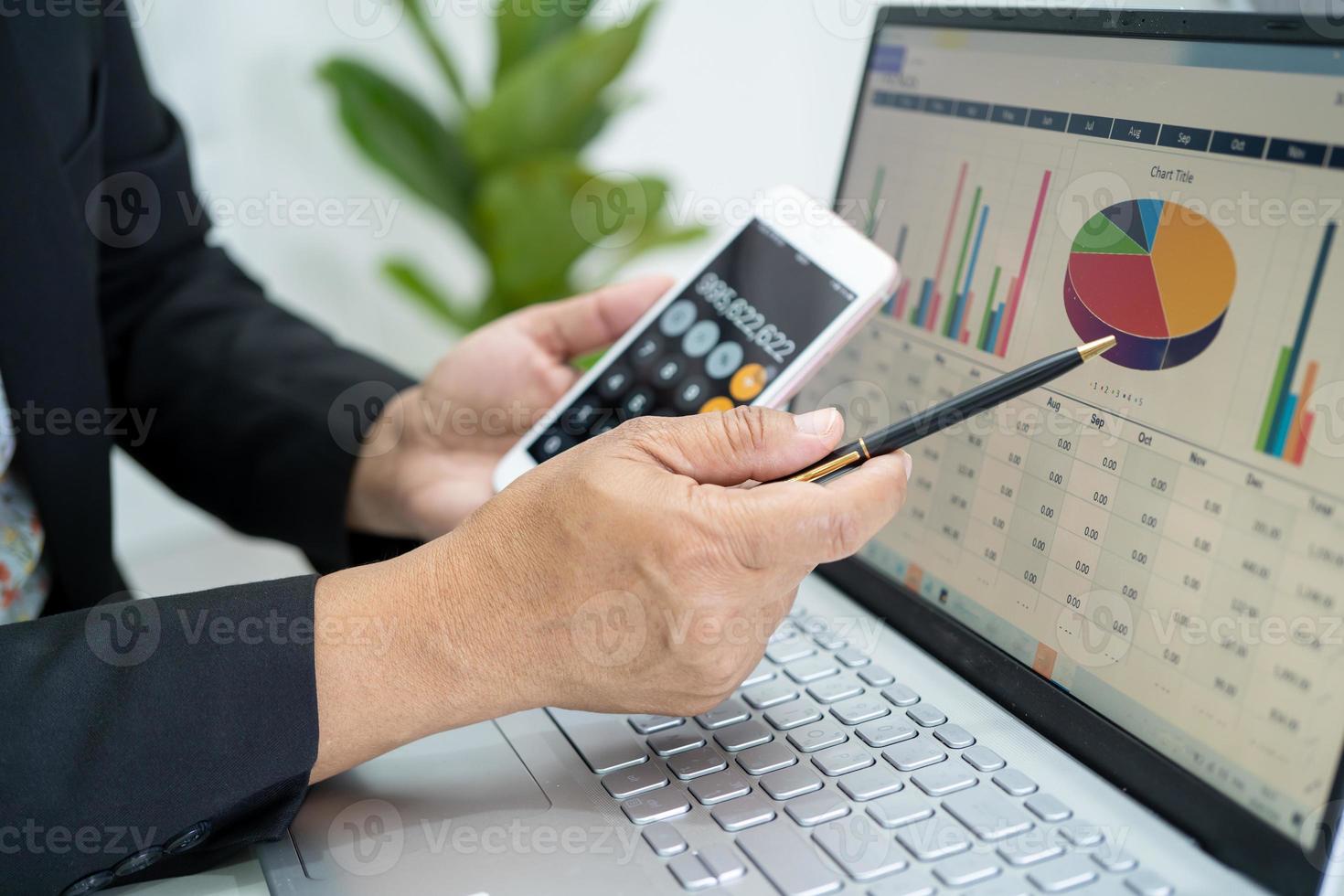 Asian accountant working and analyzing financial reports project accounting with chart graph and calculator in modern office, finance and business concept. photo