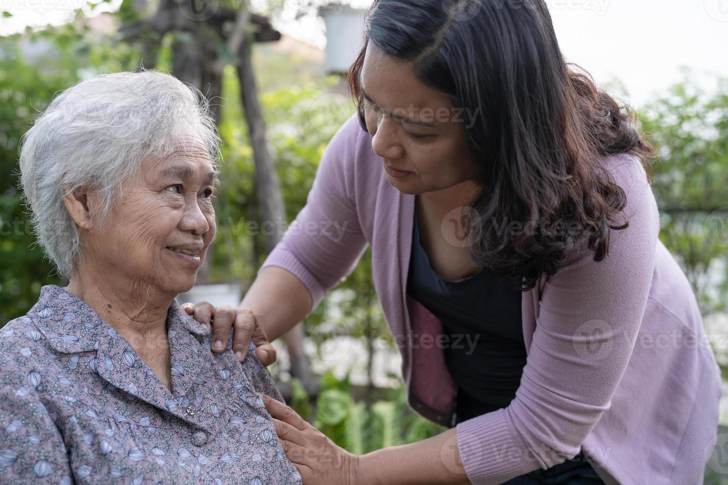 Caregiver daughter help Asian senior or elderly old lady woman on electric wheelchair in park. photo