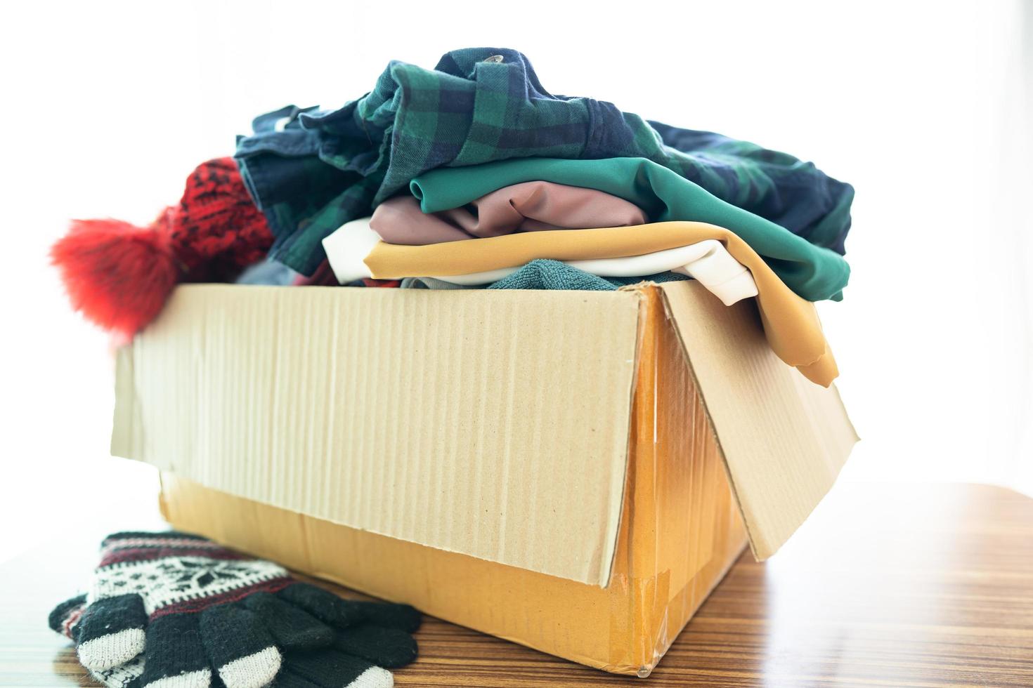 Donation box with used clothes at home to support help for poor people in the world. photo