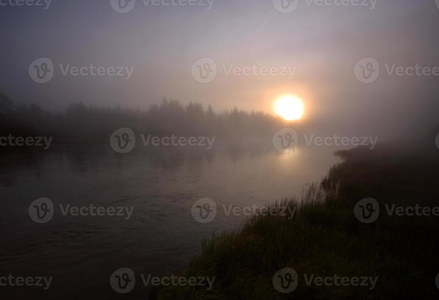 Sun rising through a morning fog photo