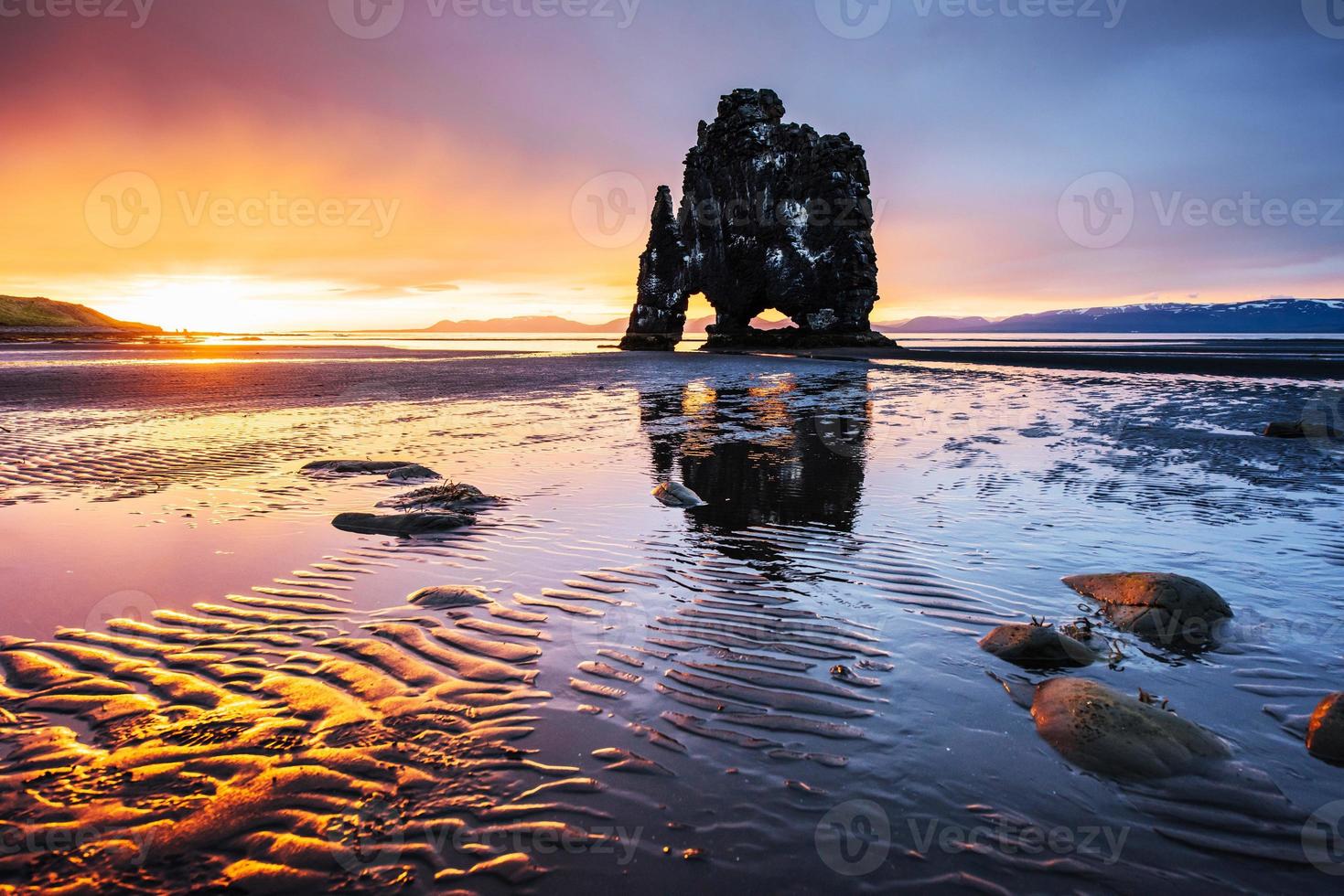 Is a spectacular rock in the sea on the Northern coast of Iceland. Legends say it is a petrified troll. On this photo Hvitserkur reflects in the sea water after the midnight sunset
