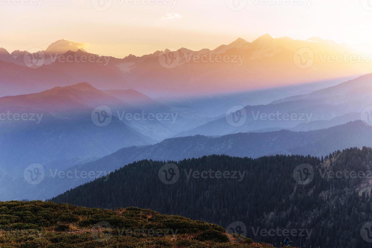 puesta de sol sobre los picos de las montañas cubiertas de nieve. la vista desde las montañas hasta el monte ushba mheyer, georgia. Europa foto