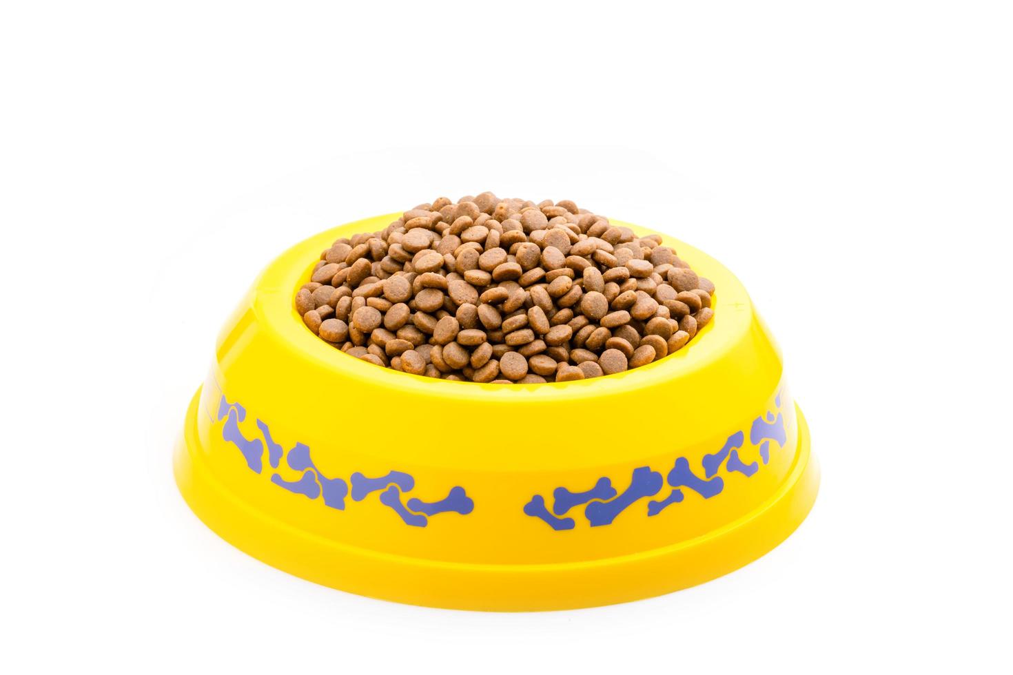 Dog food in yellow plastic bowl isolated on white photo