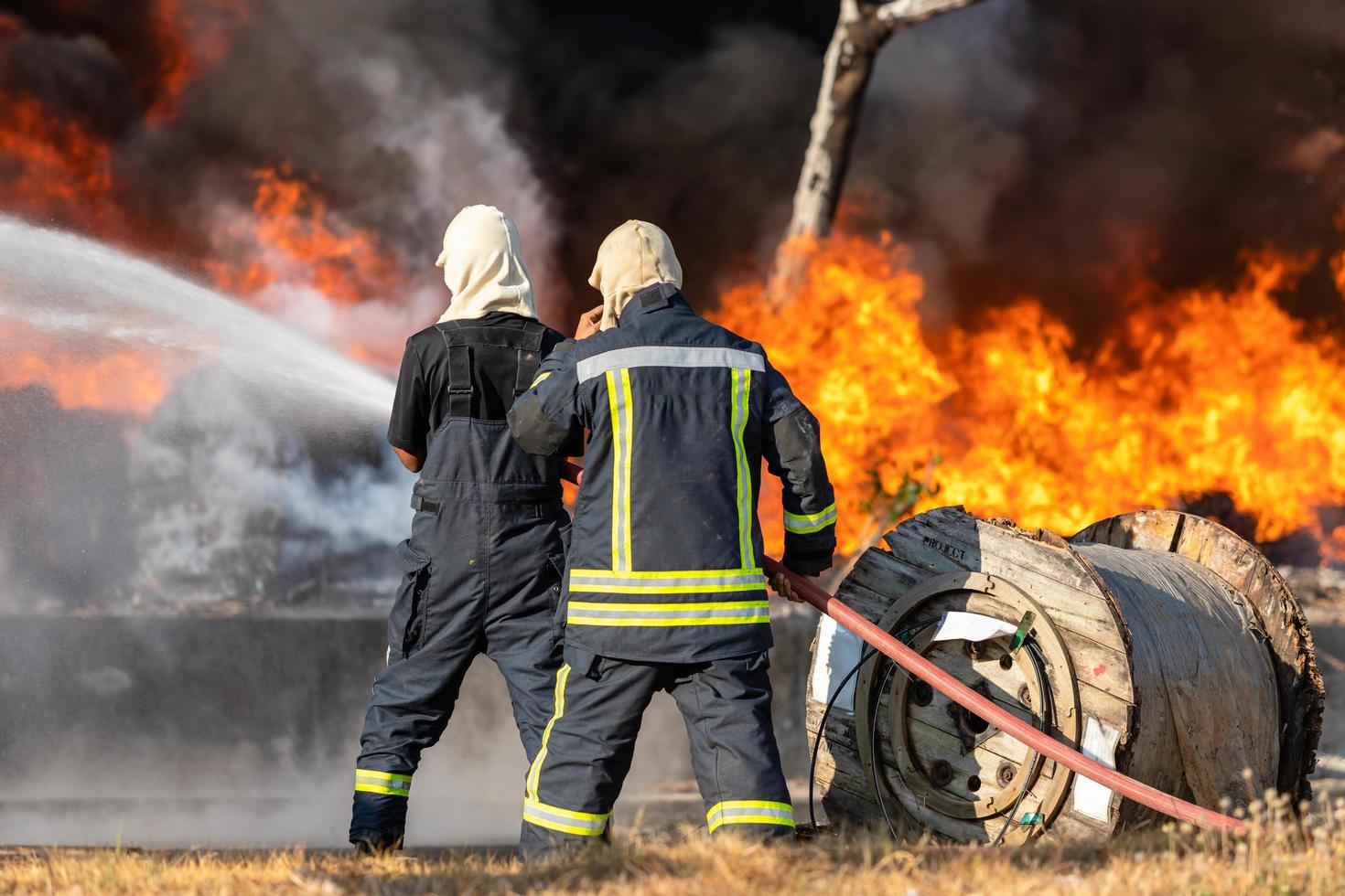 bombero rociando agua de una gran manguera de agua para prevenir incendios foto