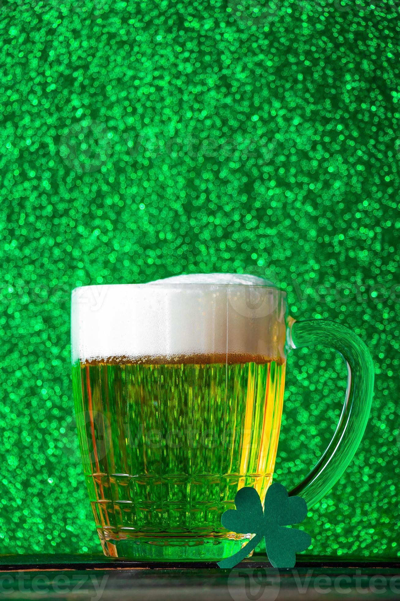Mug of light beer with foam on a green background. Traditional Irish