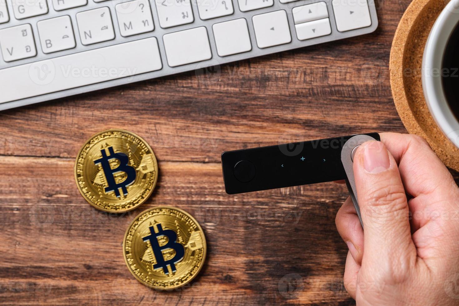 hand holding hardware wallet and transfer bitcoin and ethereum crypto currency to wallet for safety photo
