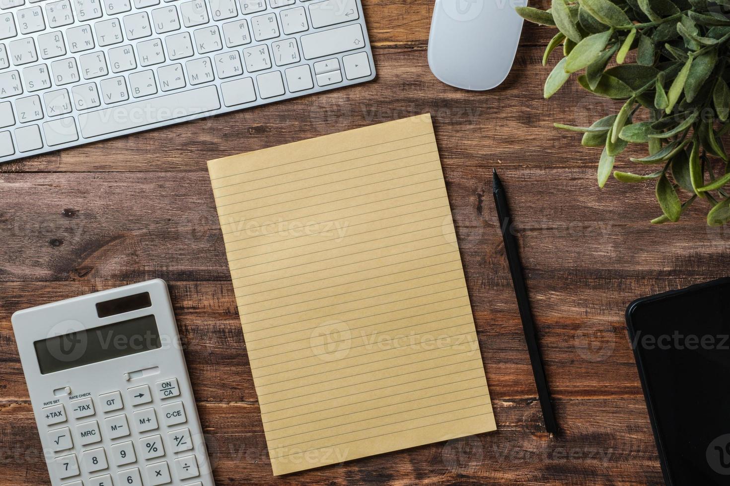 vista superior mesa de madera con calculadora y escritorio de trabajo portátil en casa foto