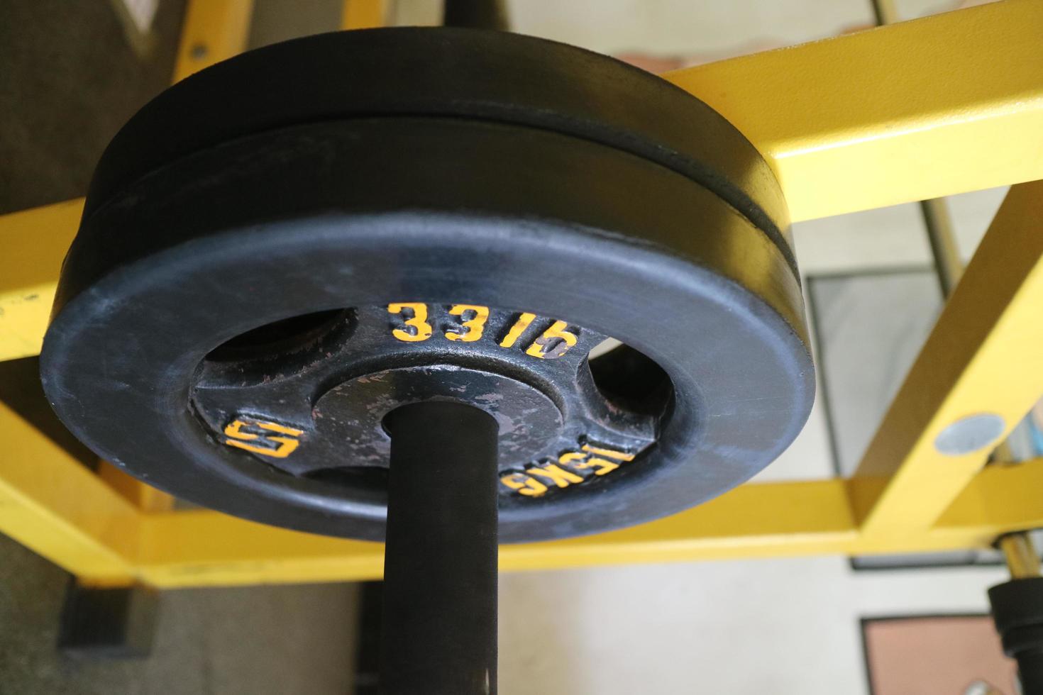 Editorial image of a 15 KG black barbell plate for exercising in the gym photo