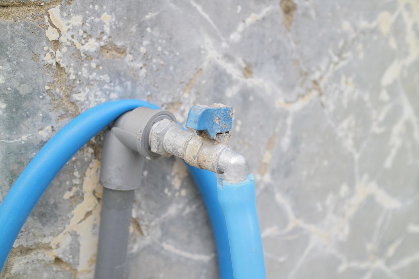 water faucet and hose in front of the house photo