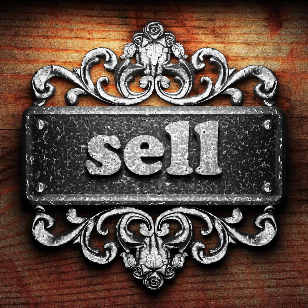 sell word of iron on wooden background photo