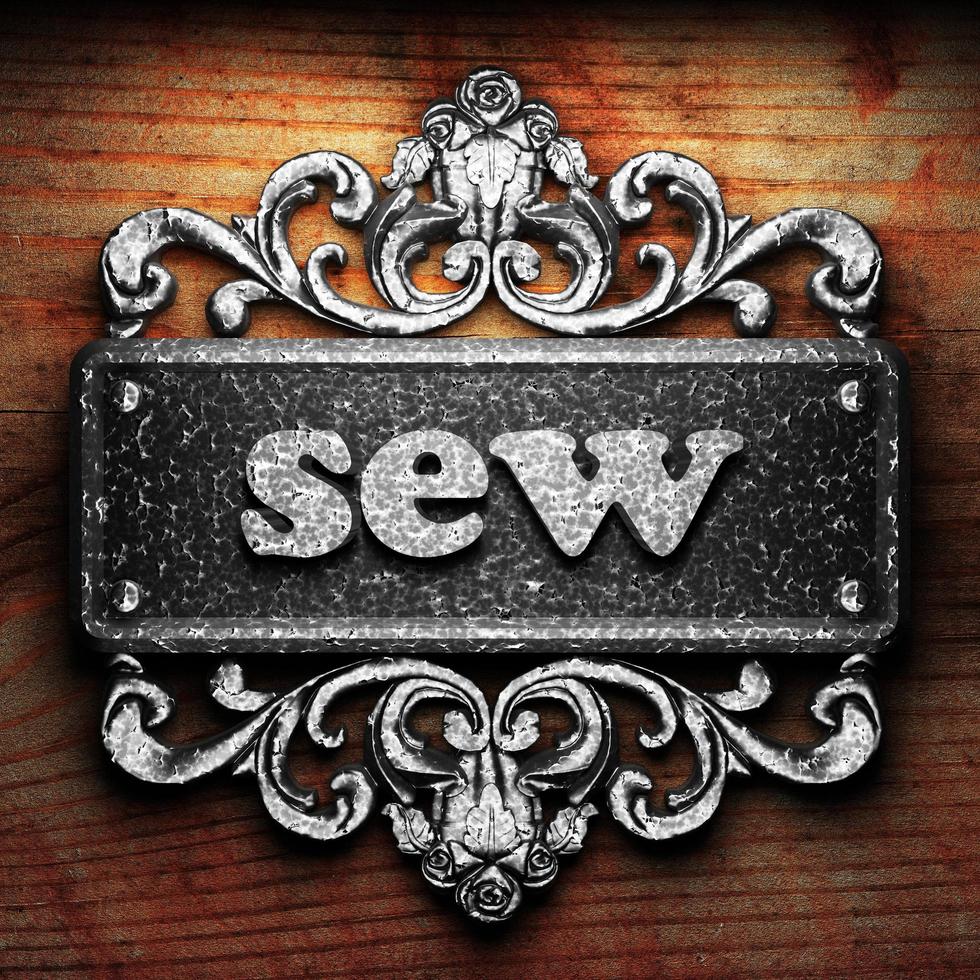 sew word of iron on wooden background photo