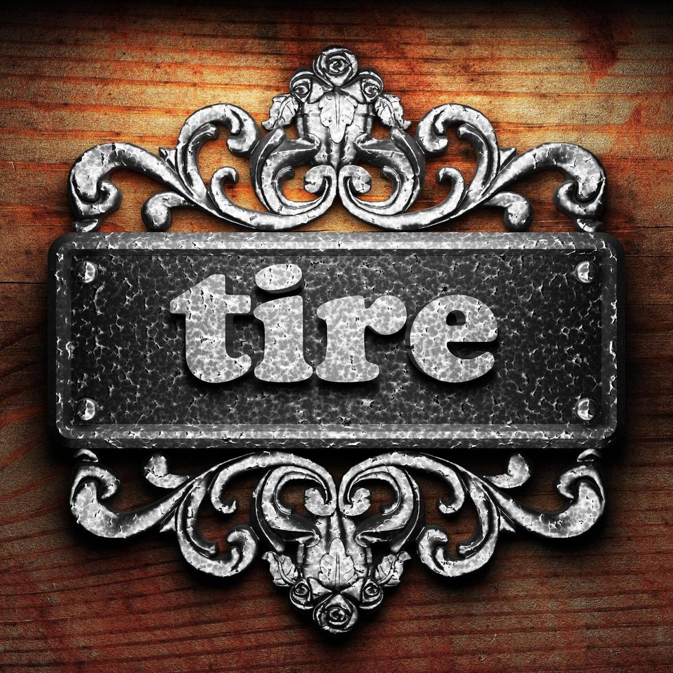 tire word of iron on wooden background photo