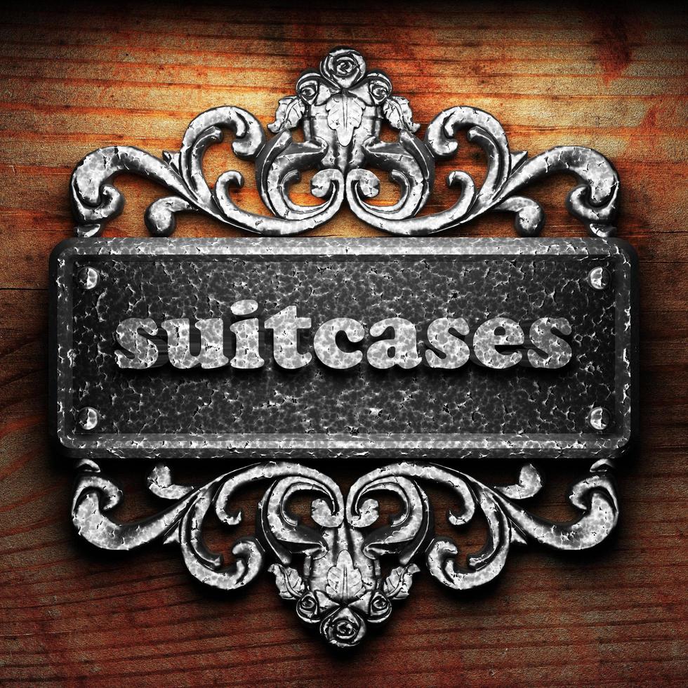 suitcases word of iron on wooden background photo