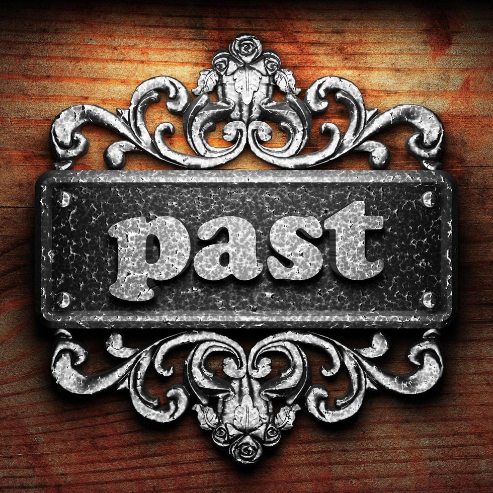 past word of iron on wooden background photo