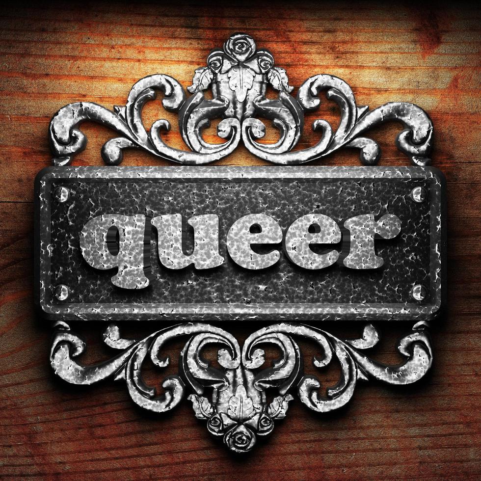 queer word of iron on wooden background photo