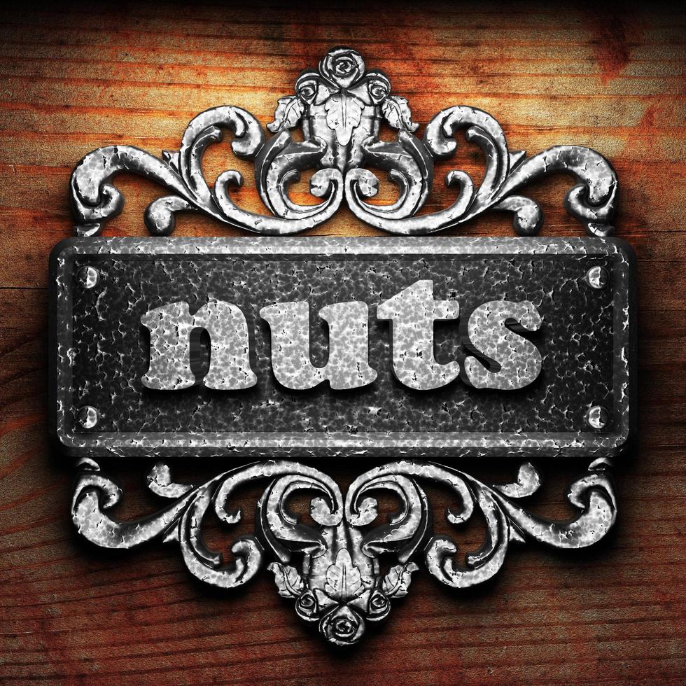 nuts word of iron on wooden background photo