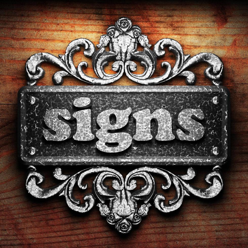 signs word of iron on wooden background photo