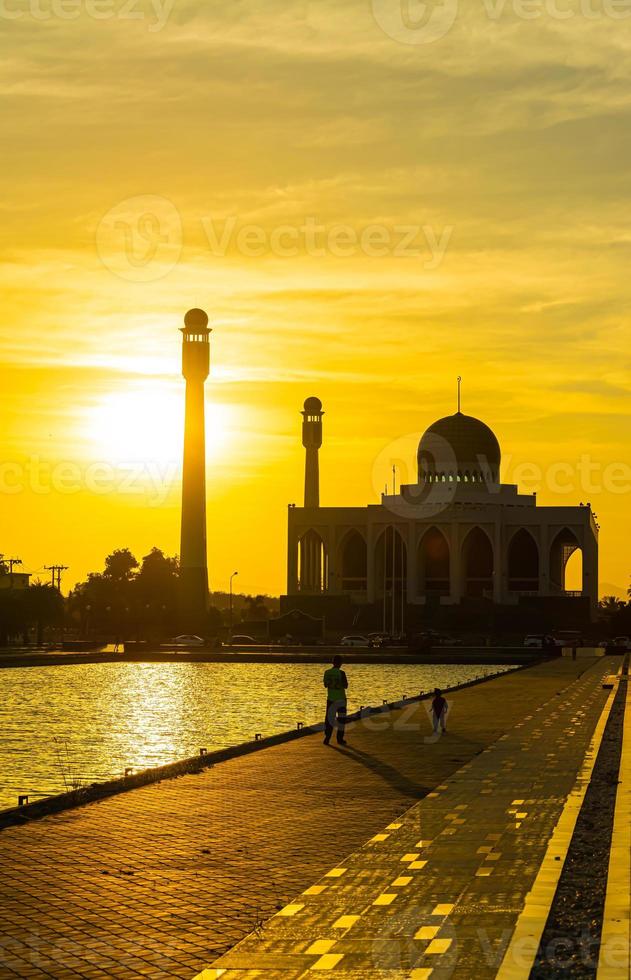 mezquita central de songkhla de día a noche con cielos coloridos al atardecer y las luces de la mezquita y reflejos en el agua en un concepto de paisaje emblemático foto